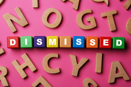 Word Dismissed made of colorful cubes on pink background, top view