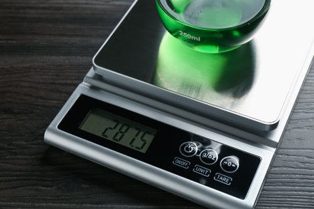 Laboratory scale with flask of sample on wooden table, closeupの写真素材