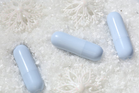 Moisturizing lip balms and Christmas decor on artificial snow, flat lay. Winter careの写真素材