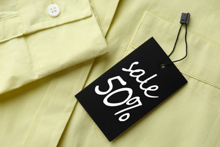 Black Sale tag on light green shirt, top viewの写真素材
