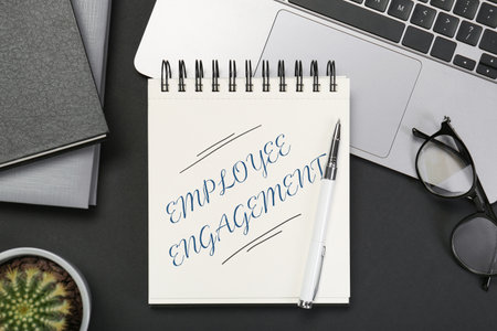 Employee engagement. Words in notebook, pen and laptop on black table, top viewの写真素材