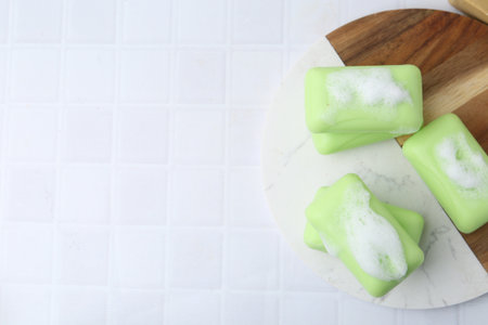 Soap bars with foam on white table, top view. Space for textの写真素材
