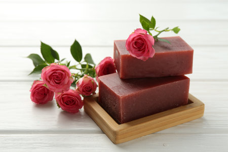 Soap bars and beautiful roses on white wooden table, closeupの写真素材