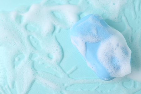 Soap bar with foam on light blue background, top view. Space for textの写真素材