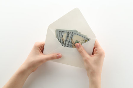 Money bonus. Woman holding envelope with dollar banknotes on white background, closeupの写真素材