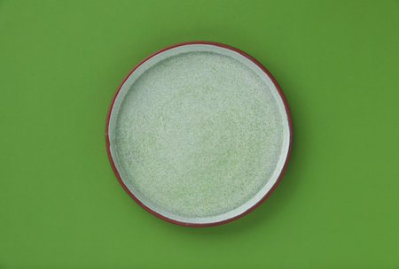 One empty plate on green background, top viewの写真素材