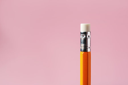 One pencil with eraser on pink background, closeup. Space for textの写真素材