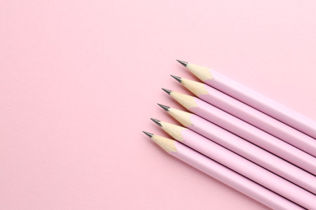 Many graphite pencils on pink background, flat lay. Space for textの写真素材