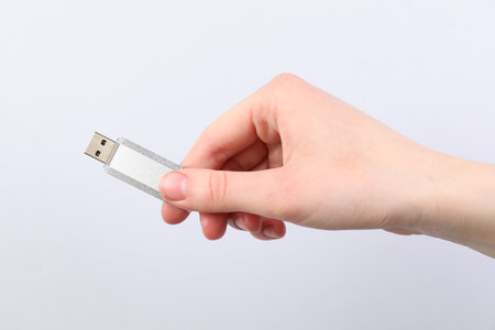 Man with modern flash drive on light grey background, closeupの写真素材