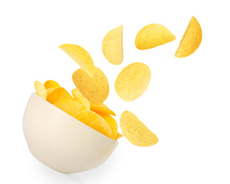 Tasty crispy potato chips falling into bowl on white backgroundの写真素材