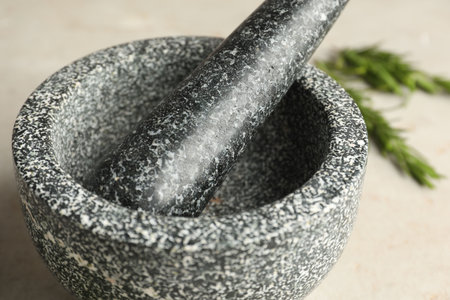 Stone mortar with rosemary and pestle on light table, closeupの写真素材