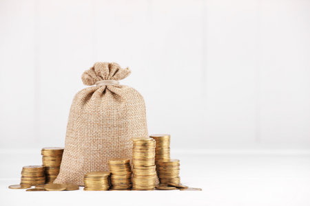 Bag and stacked coins on white background, space for textの写真素材