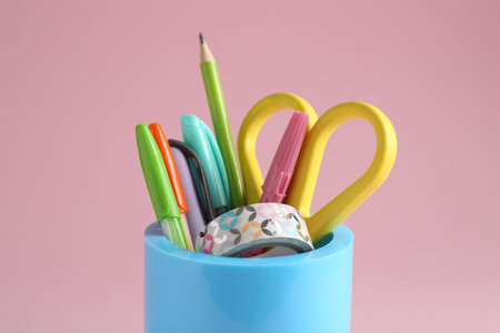 Different stationery in pen holder on pink background, closeupの写真素材