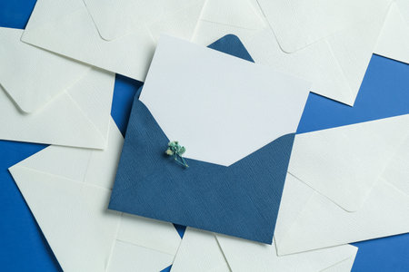 Blank invitation card and envelopes on blue background, flat lay. Space for design