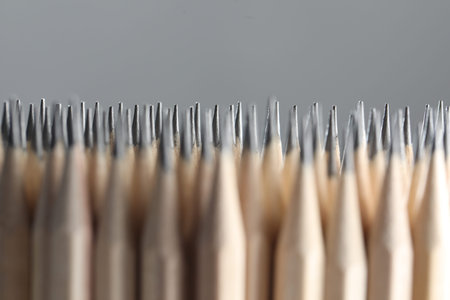 Many graphite pencils on grey background, closeup