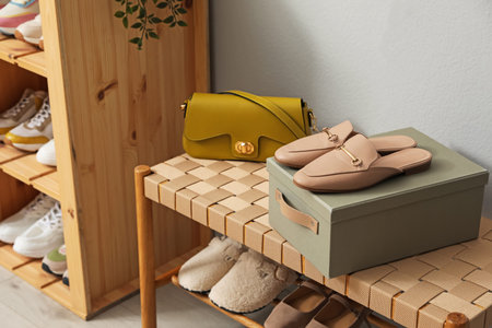 Different footwear on bench indoors. Shoe storage