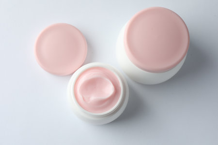Jars of moisturizing body cream on white background, flat layの写真素材