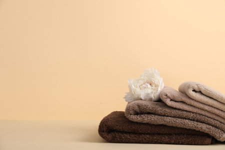 Soft towels and peony flower on beige background, space for textの写真素材