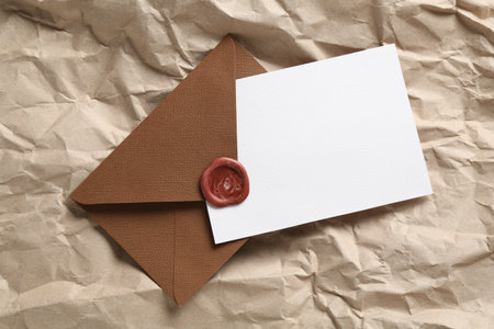 Blank invitation card and envelope on parchment paper, top view. Space for designの写真素材