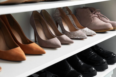 Different footwear on shelves indoors, closeup. Shoe storageの写真素材