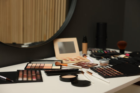 Different makeup products and brushes on dressing table indoorsの写真素材