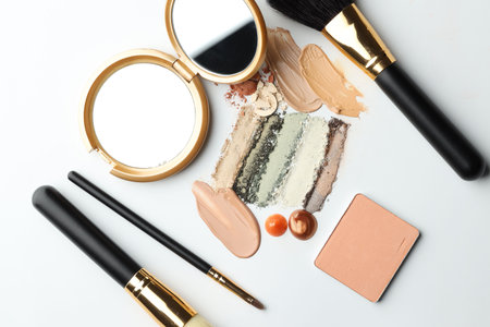 Different cosmetic products, makeup brushes and mirror on white background, flat layの写真素材