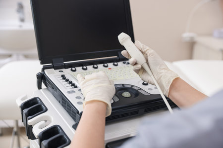 Sonographer with transducer and ultrasound machine in clinic, closeupの写真素材