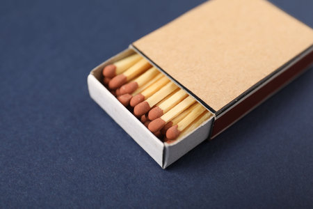 Matches in box on blue background, closeup. Mockup for designの写真素材