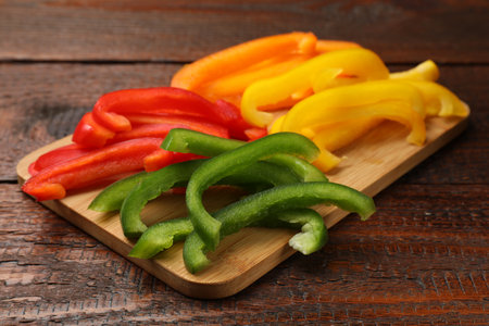 Cut colorful bell peppers on wooden table, closeupの写真素材