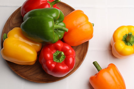Fresh colorful bell peppers on white table, flat lay