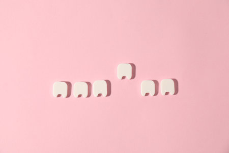Small teeth figures on pink background, flat layの写真素材