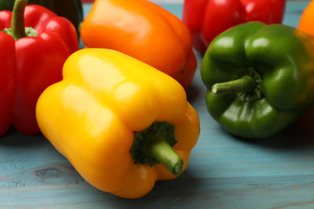 Fresh colorful bell peppers on blue wooden table, closeupの写真素材