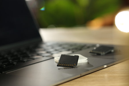 SD memory cards, holder and laptop on wooden table, closeupの写真素材