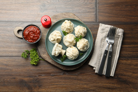Delicious khinkali served with cilantro on wooden table, flat layの写真素材