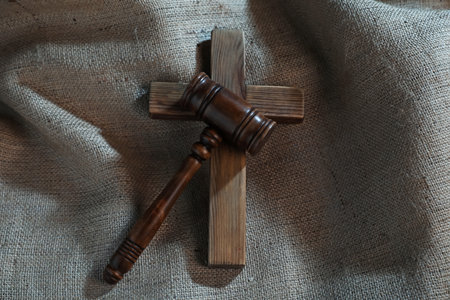 Judge's gavel and wooden cross on burlap fabric, top viewの写真素材