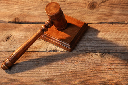 Judge's gavel on wooden table, above view. Space for text