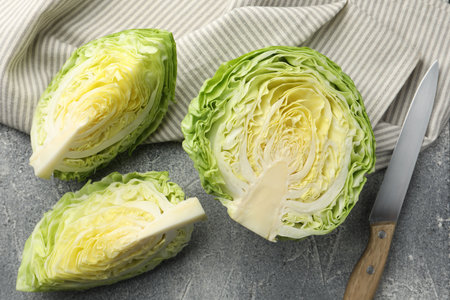 Pieces of fresh cabbage and knife on grey table, flat layの写真素材