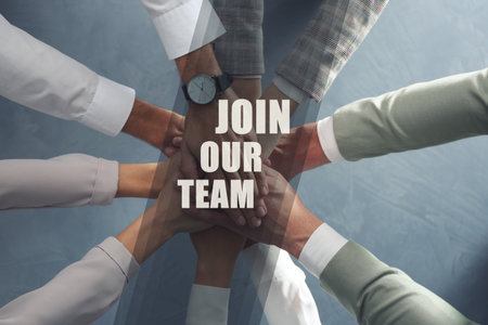 Join Our Team. Group of people holding hands together at grey table, top view. Employee search, recruitment conceptの写真素材