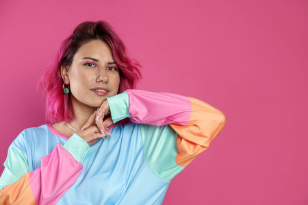 Beautiful woman with bright dyed hair on pink background, space for text