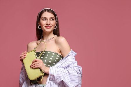 Fashionable portrait of beautiful woman in stylish outfit on pink background. Space for textの写真素材