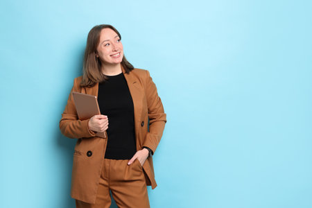 Woman with modern tablet on light blue background, space for textの写真素材