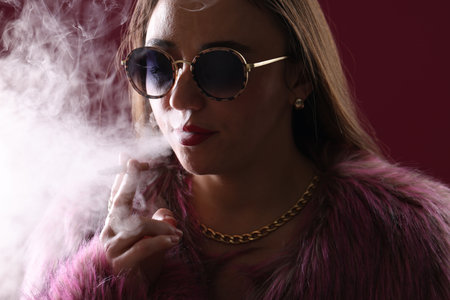 Beautiful woman in fur coat smoking cigarette on dark pink background, closeup