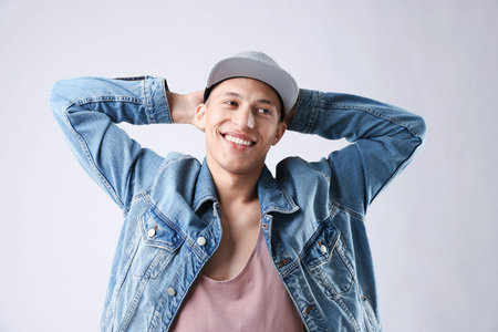 Young man in stylish baseball hat on light grey background