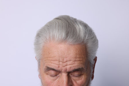 Man with silver hair on light background, closeupの写真素材