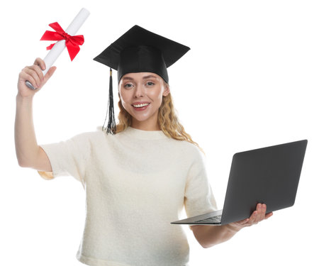 Happy student with diploma and laptop after graduation on white backgroundの写真素材
