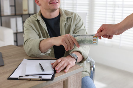 Bonus. Employee receiving money from boss in office, closeup