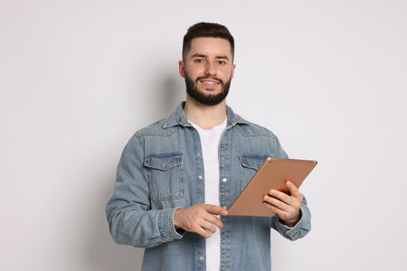 Handsome man using tablet on white backgroundの写真素材