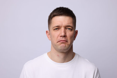 Portrait of a stressed man on light background