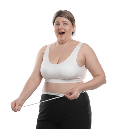 Weight loss. Emotional plus size woman measuring waist with tape on white backgroundの写真素材