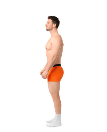 Young man in stylish orange underwear on white backgroundの写真素材